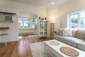 A living room with a sofa, a coffee table, a cabinet, and a floor lamp.