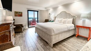 A bedroom with a large bed, a television, a chair, and a view of the ocean. - OF Escape with Private Porch 1st Flr Full Kitchen (Pawleys Island)