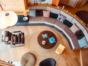 A modern living room with a curved sectional sofa, a round coffee table, and a large rug.