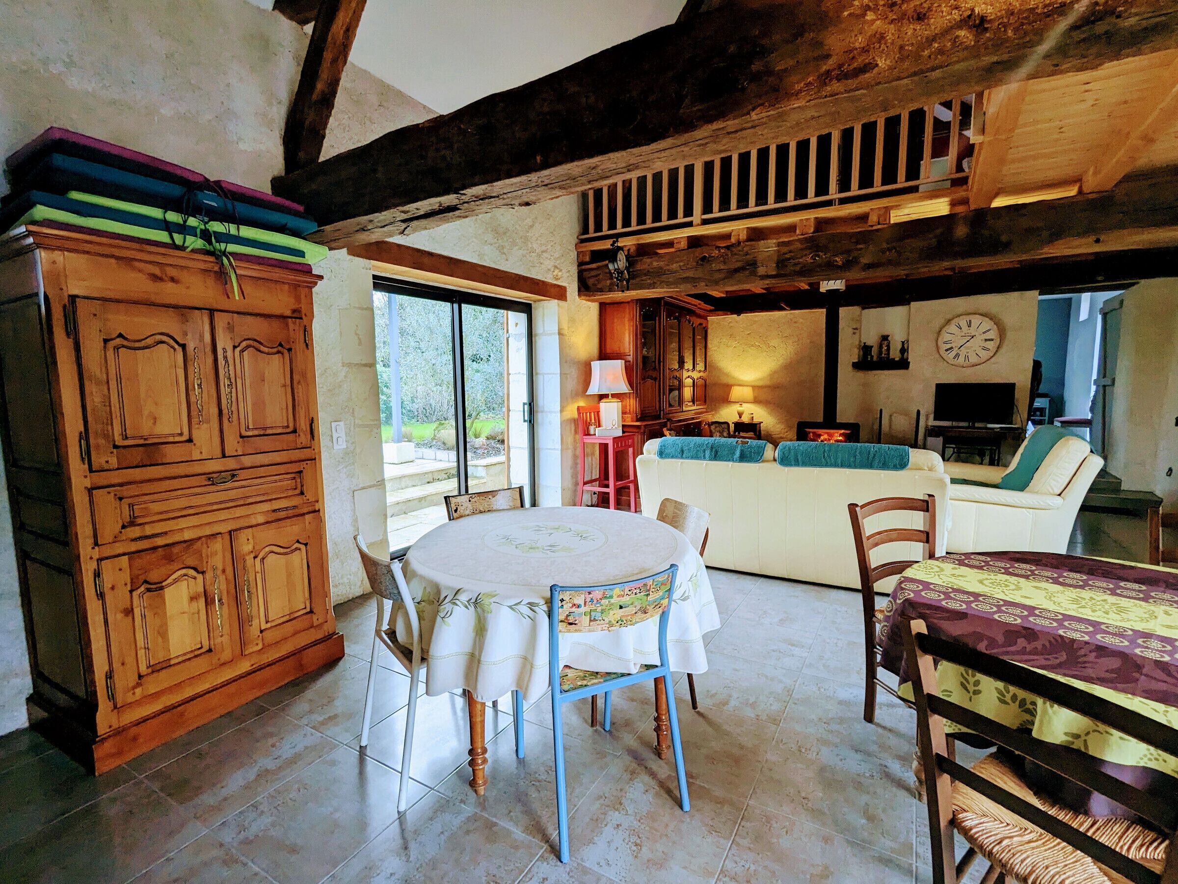 Una sala de estar acogedora con comedor, armarios de madera, un sofá y un televisor.