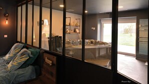 Una habitación moderna con un amplio ventanal, un sofá y una zona de hidromasaje.