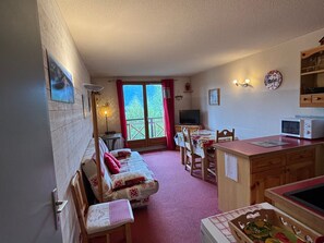 Une pièce confortable avec un canapé, une table à manger et un coin cuisine.