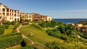A resort with multiple-story buildings, a well-maintained garden, and a view of the sea. - Cozy studio in Cap Esterel with balcony and pool access (Saint-Raphaël)