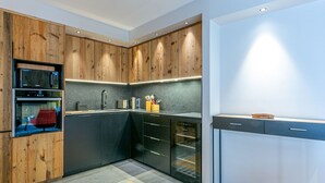A modern kitchen with wooden cabinetry, built-in appliances, and a sleek countertop.