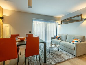 A modern living room with a dining area, a sofa, and a coffee table.