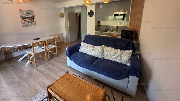 Een woonkamer met een bank, een salontafel en een eethoek met een tafel en stoelen.