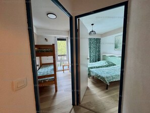 A room with bunk beds and a bed with patterned bedding.