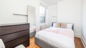 A bedroom with a bed, a dresser, and a window. - Luxury Apartment London Eye Westminister (London)