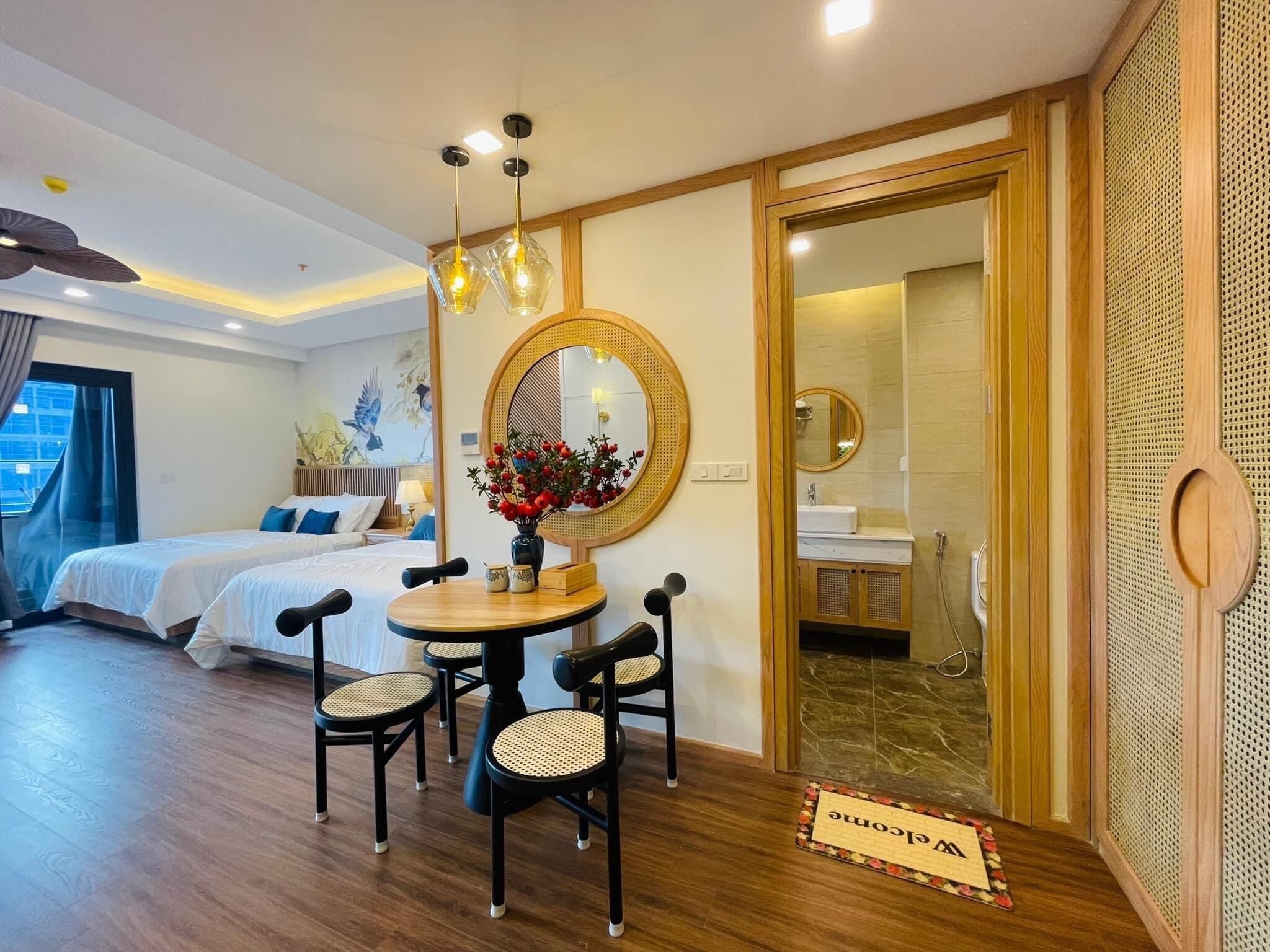 Una habitación de hotel con cama, una mesa redonda con sillas, un espejo y vistas a la ciudad.