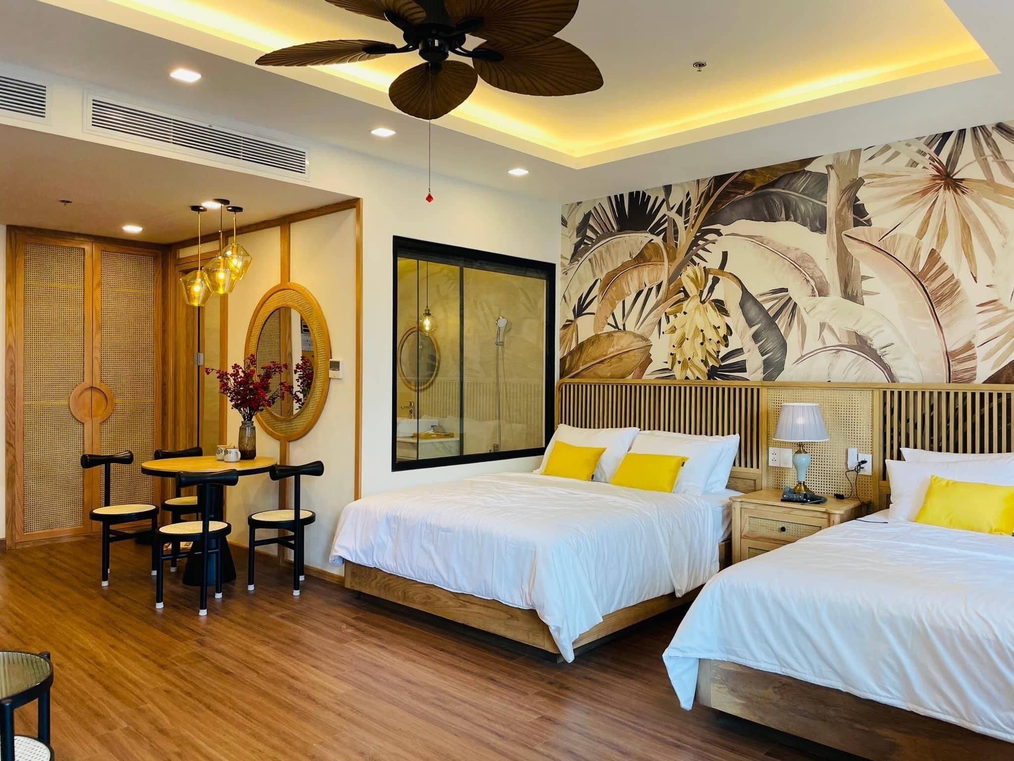 A hotel room with two beds, a dining area, and a large wall mural.