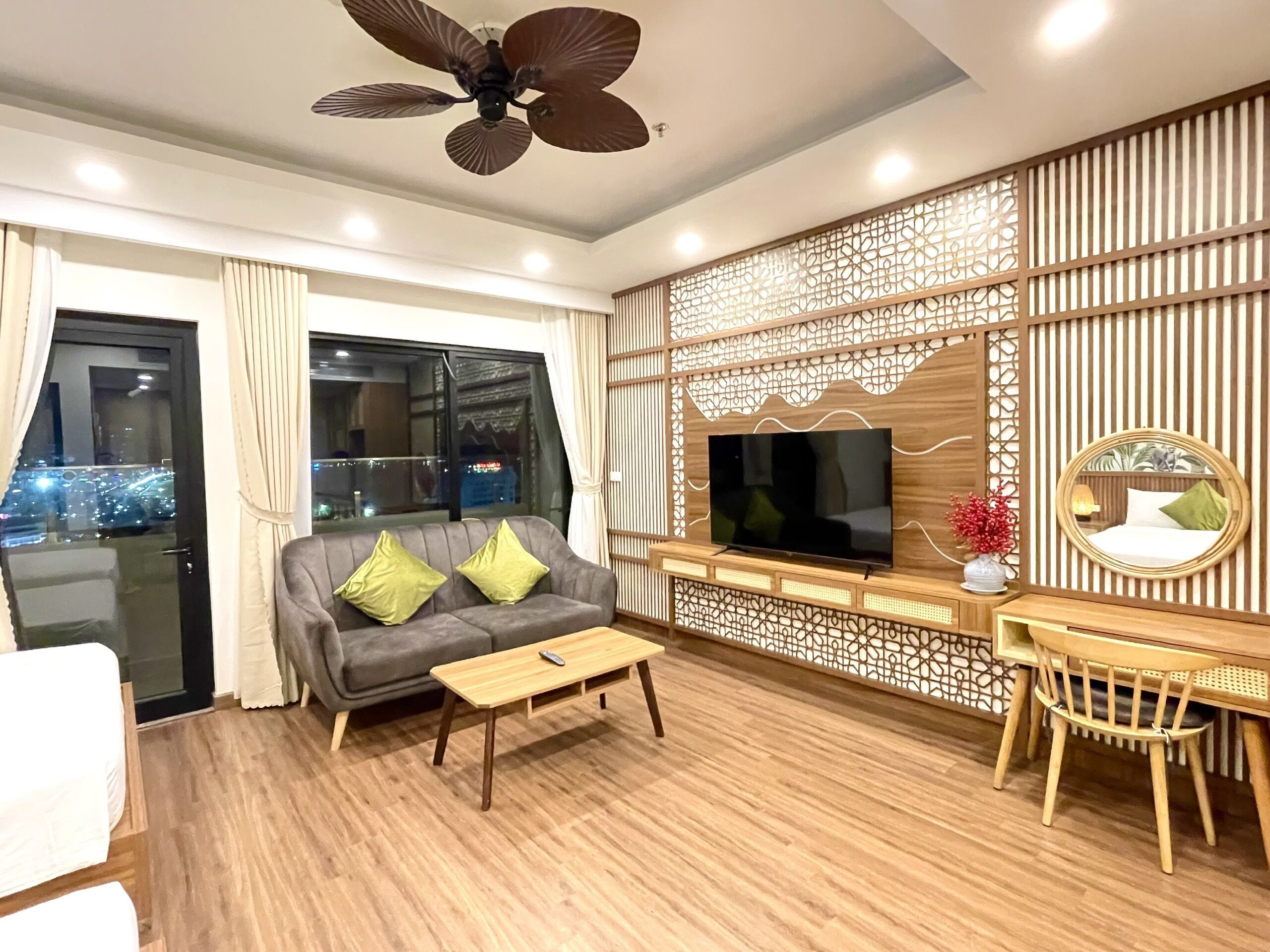 A modern living room with a sofa, coffee table, TV, and decorative wall paneling.