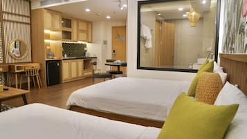 A hotel room with two beds, a dining area, and a kitchen.