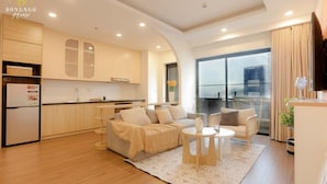 A modern apartment with a kitchen, living area, and balcony. - FLC Sea Tower - Quynhon Homes (Quy Nhon Nam)