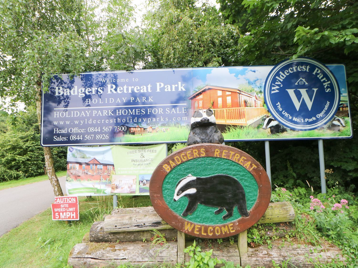 A sign for Badgers Retreat Park with a welcome message and contact information.