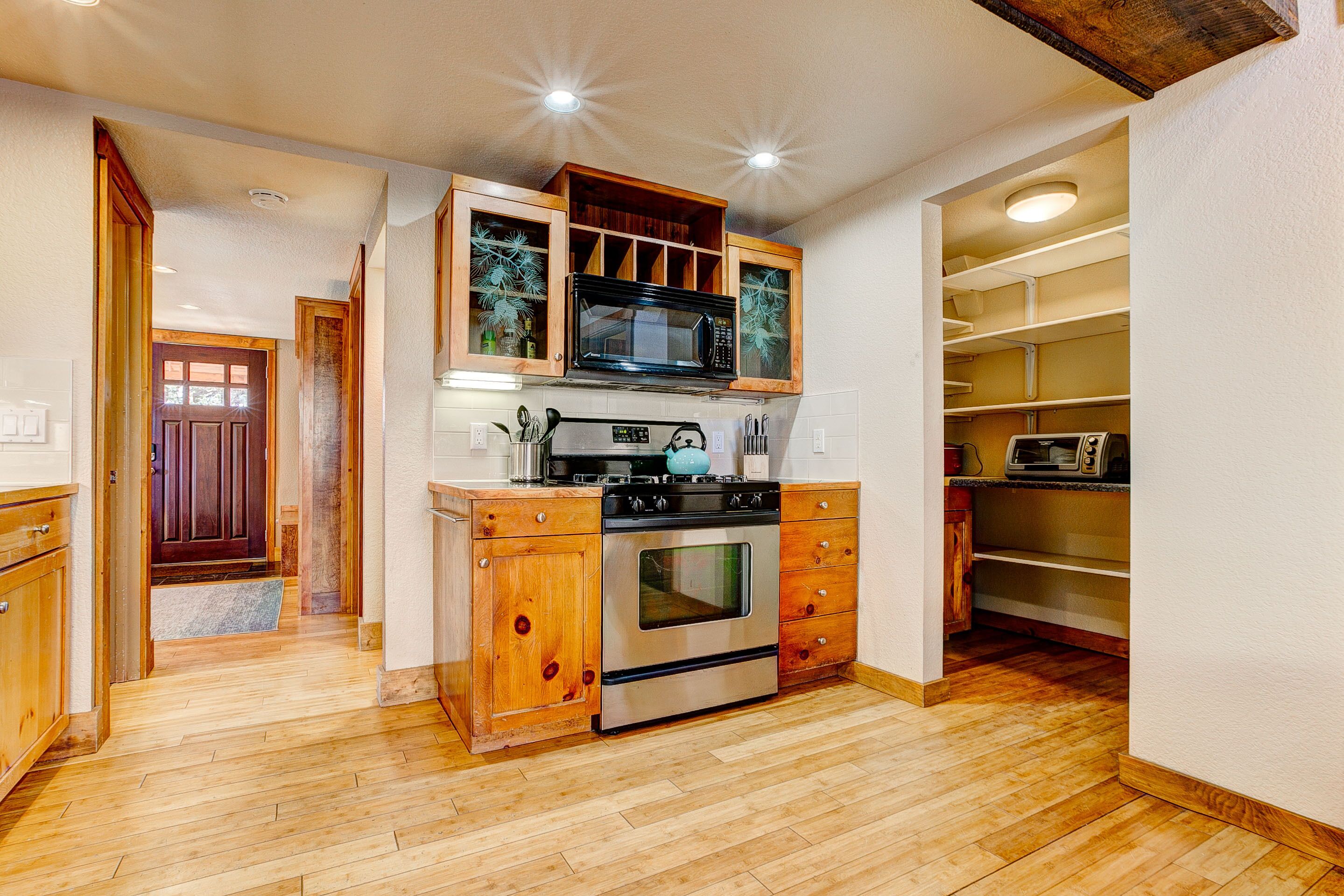 A kitchen with wooden cabinets, a stainless steel oven, and a microwave.