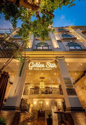 Exterior del Hotel Golden Star & Apartamentos, con una entrada imponente, grandes columnas y un balcón con barandillas ornamentales.