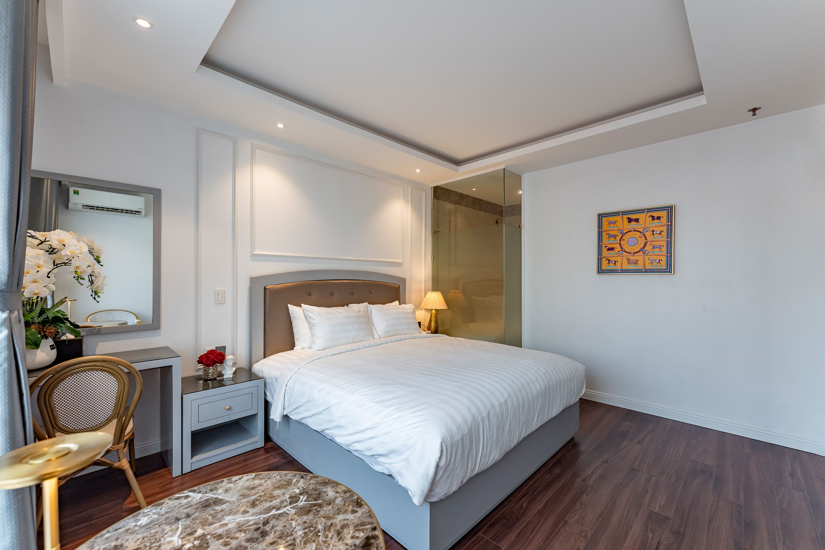 A modern bedroom with a large bed, bedside tables, a chair, and a mirror.