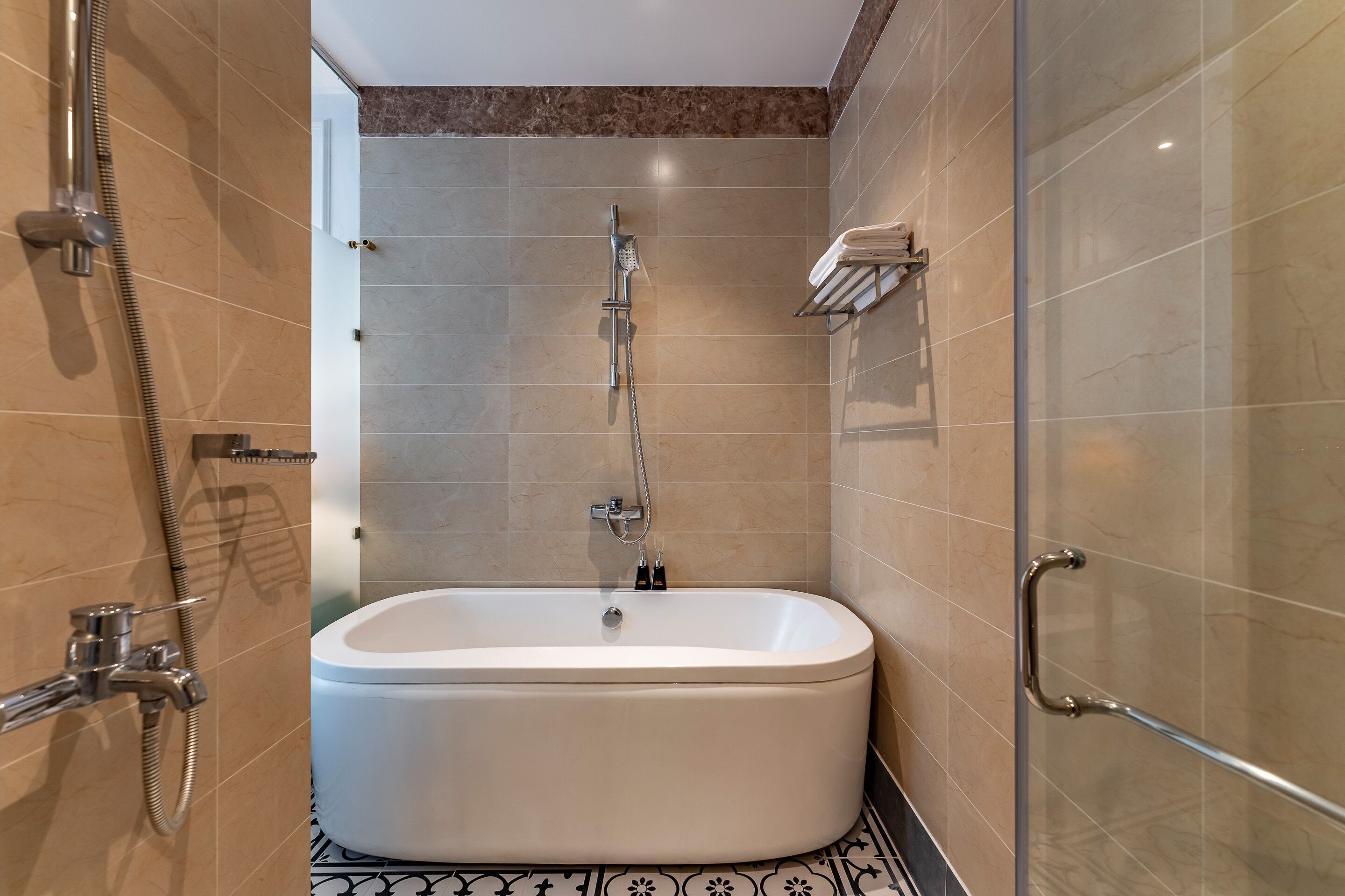 A modern bathroom with a freestanding bathtub, a glass shower enclosure, and a handrail.
