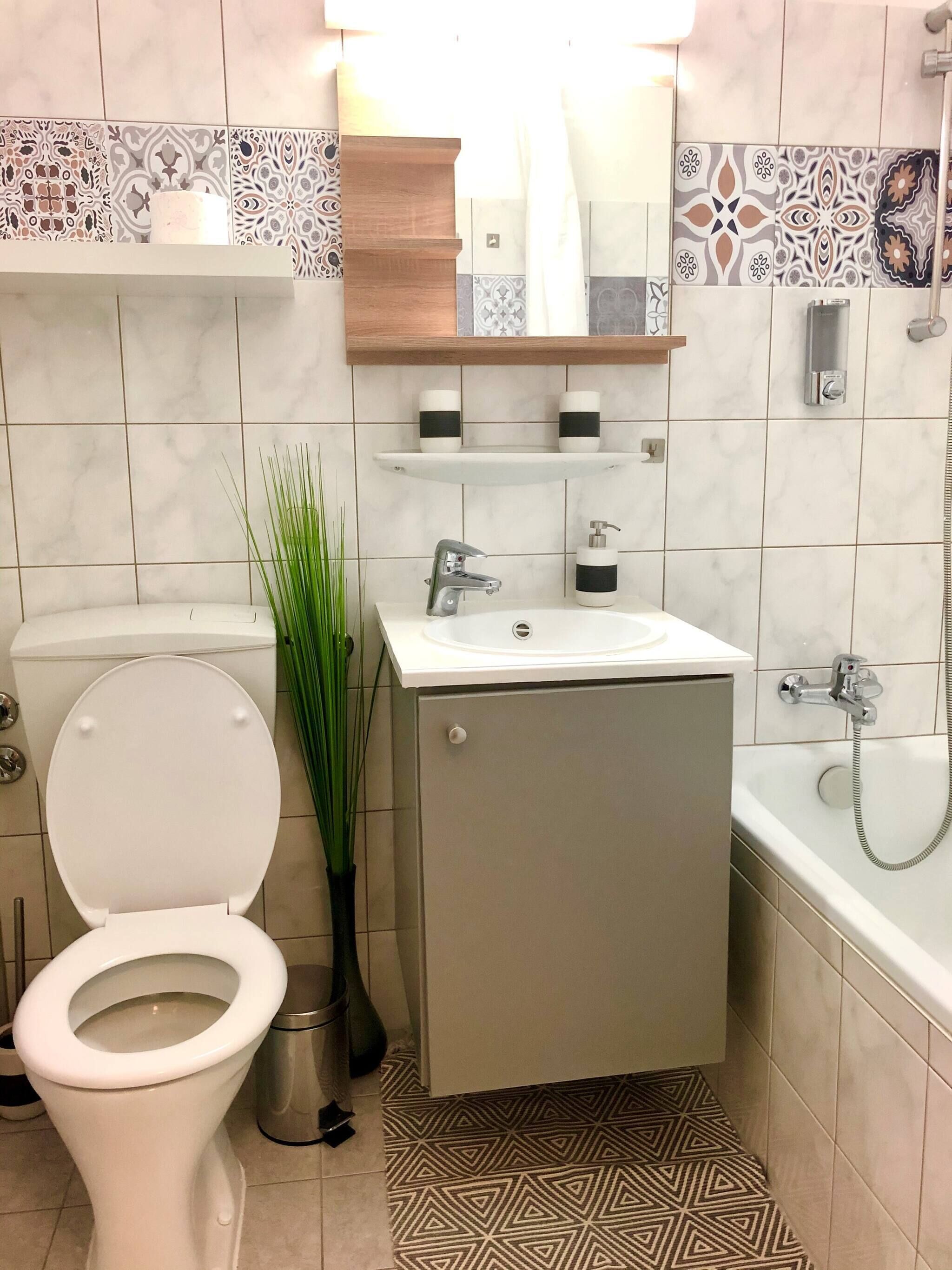 A bathroom with a toilet, sink, and bathtub.