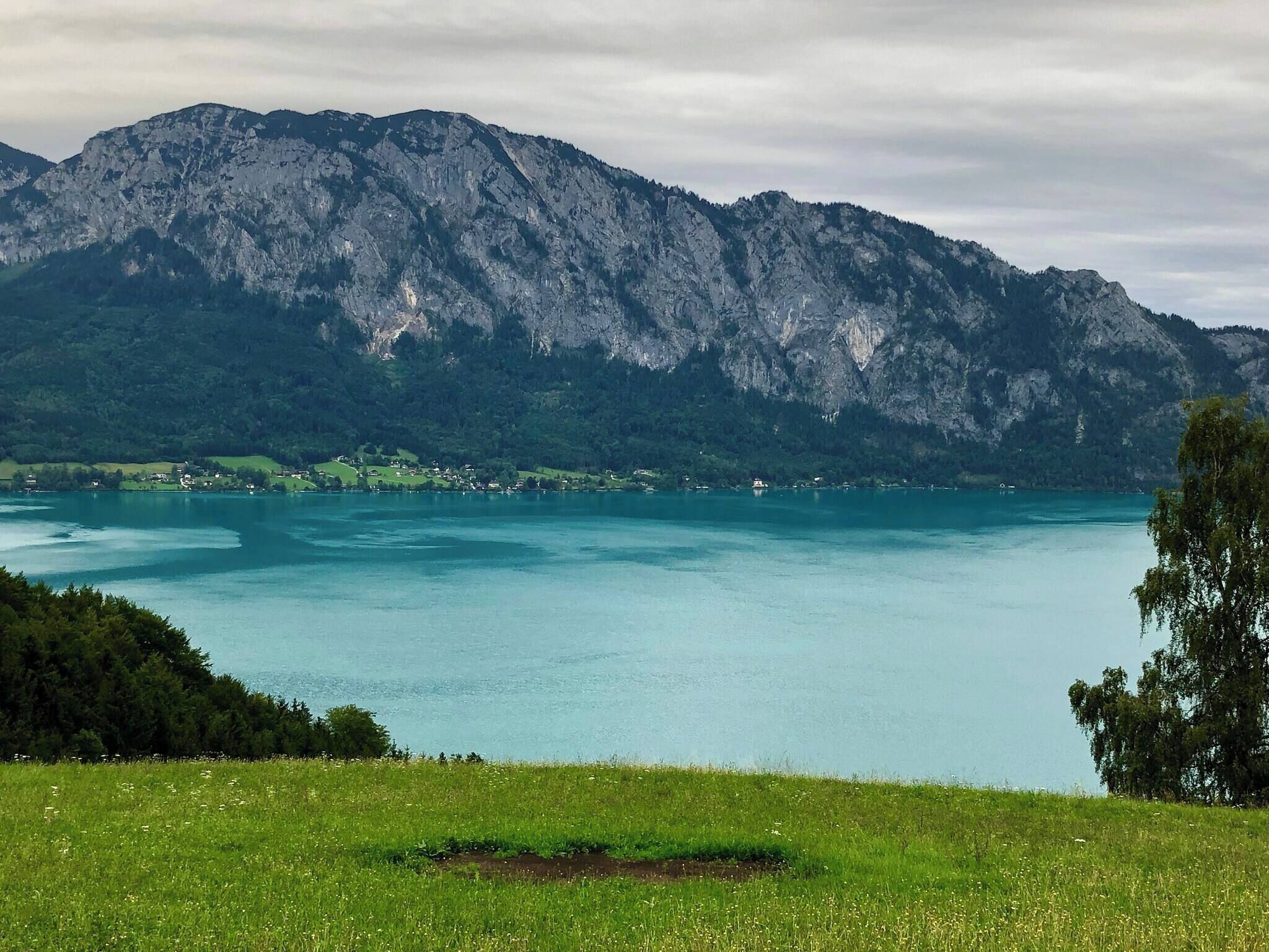 A mountainous landscape with a lake and a small settlement.