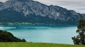 A mountainous landscape with a lake and a small settlement.
