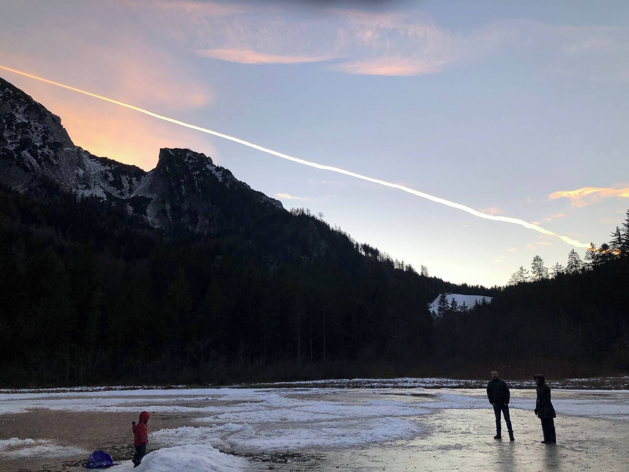A frozen river with mountains in the background and a clear sky.