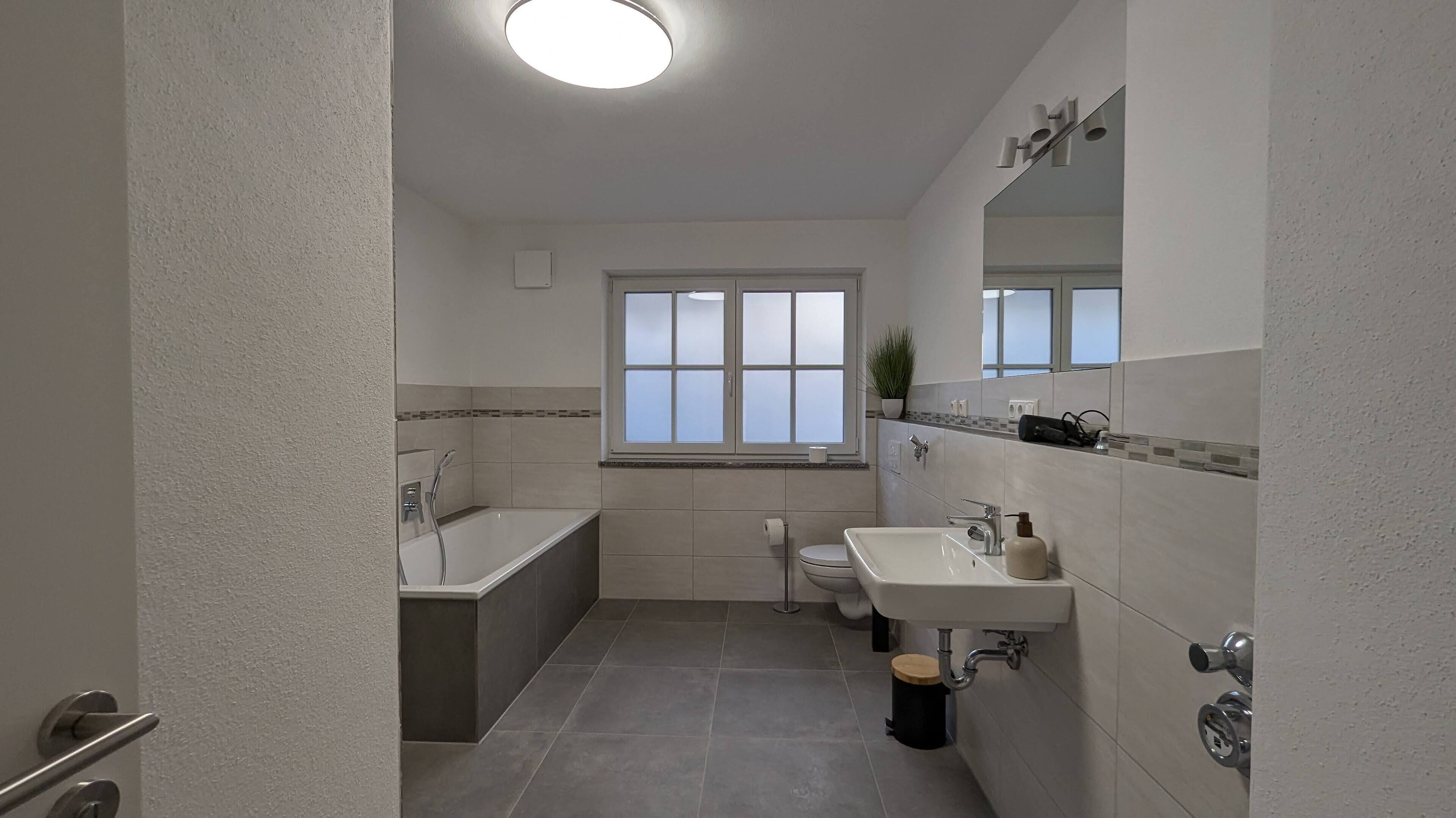Une salle de bain moderne avec une baignoire, des toilettes et un lavabo.