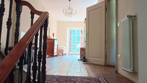 Una escalera con alfombra estampada que lleva a una habitación con radiador y puerta.
