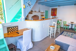 A cozy interior with a kitchen area, a dining table, and a sofa. - Pitini 1 - Seafront - Harbour view (Symi)