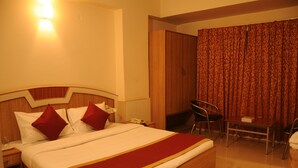 A hotel room with a large bed, a desk, and a chair. - Srinidhi Residency (Bengaluru)