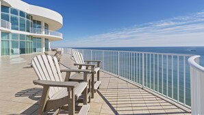 Un balcon avec des fauteuils Adirondack donnant sur l’océan.