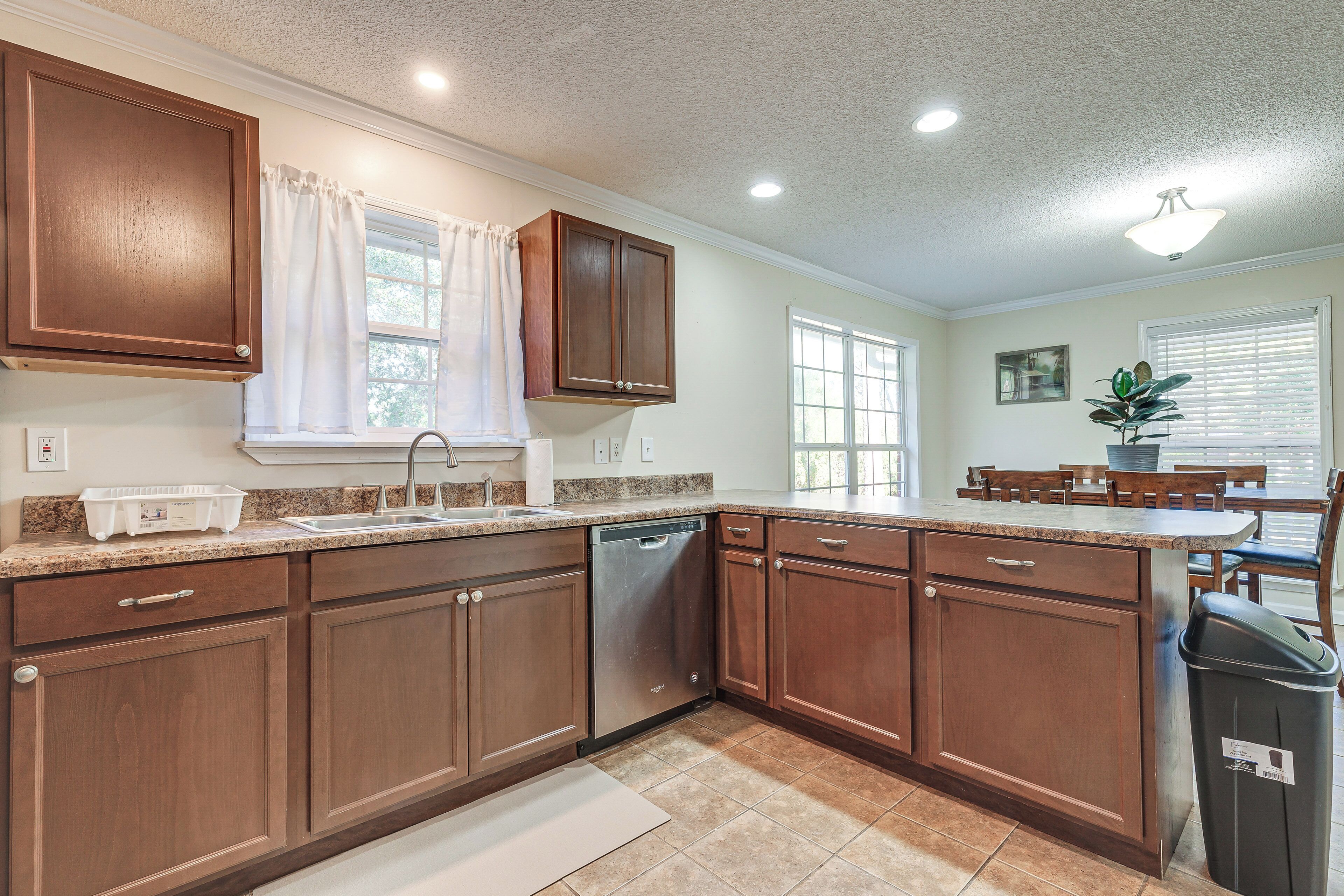 A kitchen with wooden cabinets, a dishwasher, and a countertop with a sink.