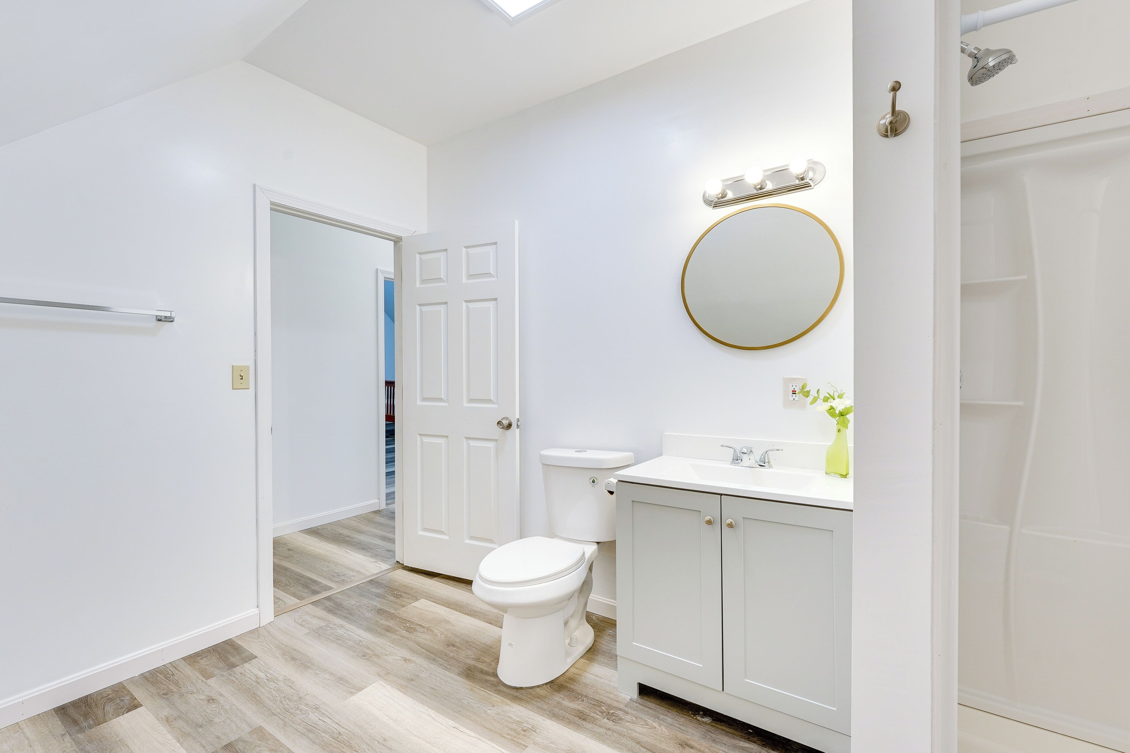A modern bathroom with a toilet, sink, and shower.