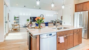 A modern kitchen with a large island, stainless steel appliances, and wooden cabinets. - Flagstaff Home w/ Fire Pit + Hiking Trail Access! (Flagstaff)