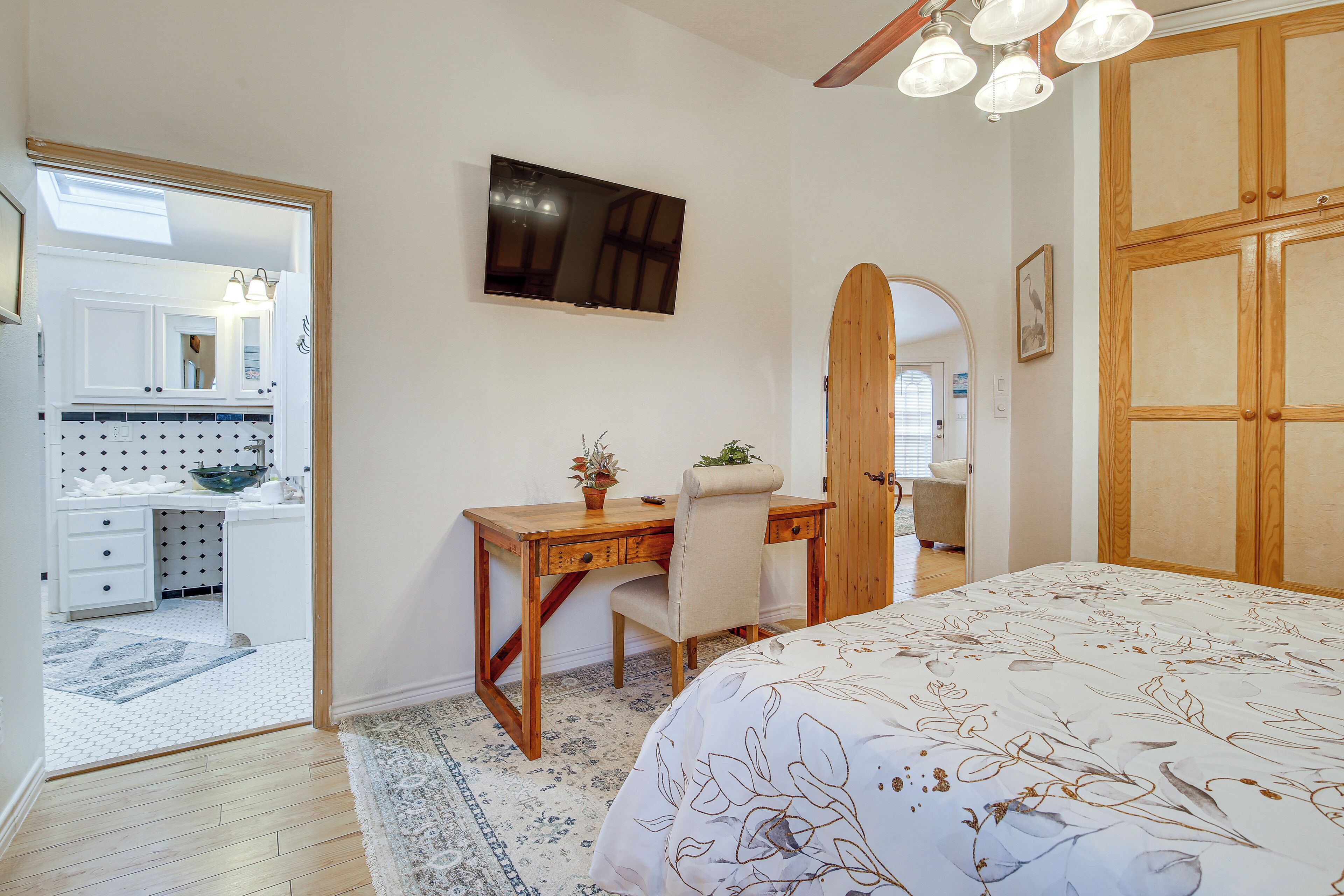 A bedroom with a bed, a desk, a chair, a television, and a wardrobe.
