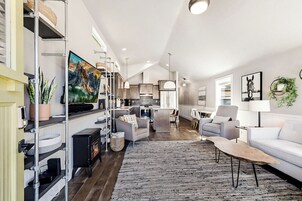 A spacious living area with a fireplace, a sofa, a coffee table, and a television.