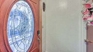 Una puerta de madera con un panel de vidrio y una pequeña placa encima.
