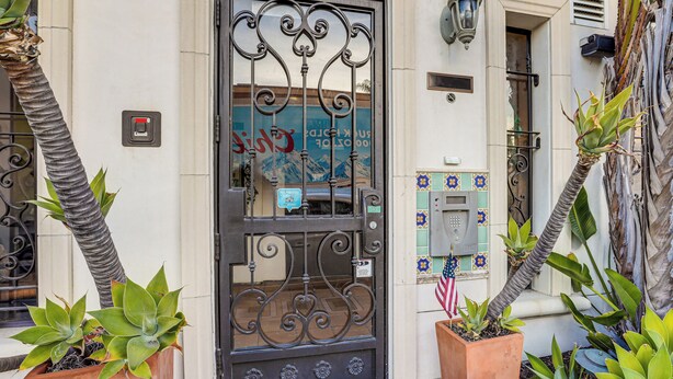 A building entrance with a wrought iron gate, potted plants, and a mailbox. - Pismo Beach Vacation Rental - Walk to Town & Ocean (Pismo Beach)
