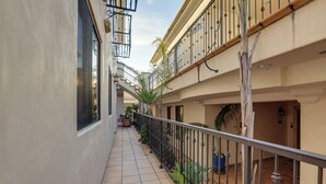 A narrow corridor with tiled flooring, potted plants, and a metal railing. - Pismo Beach Vacation Rental - Walk to Town & Ocean (Pismo Beach)