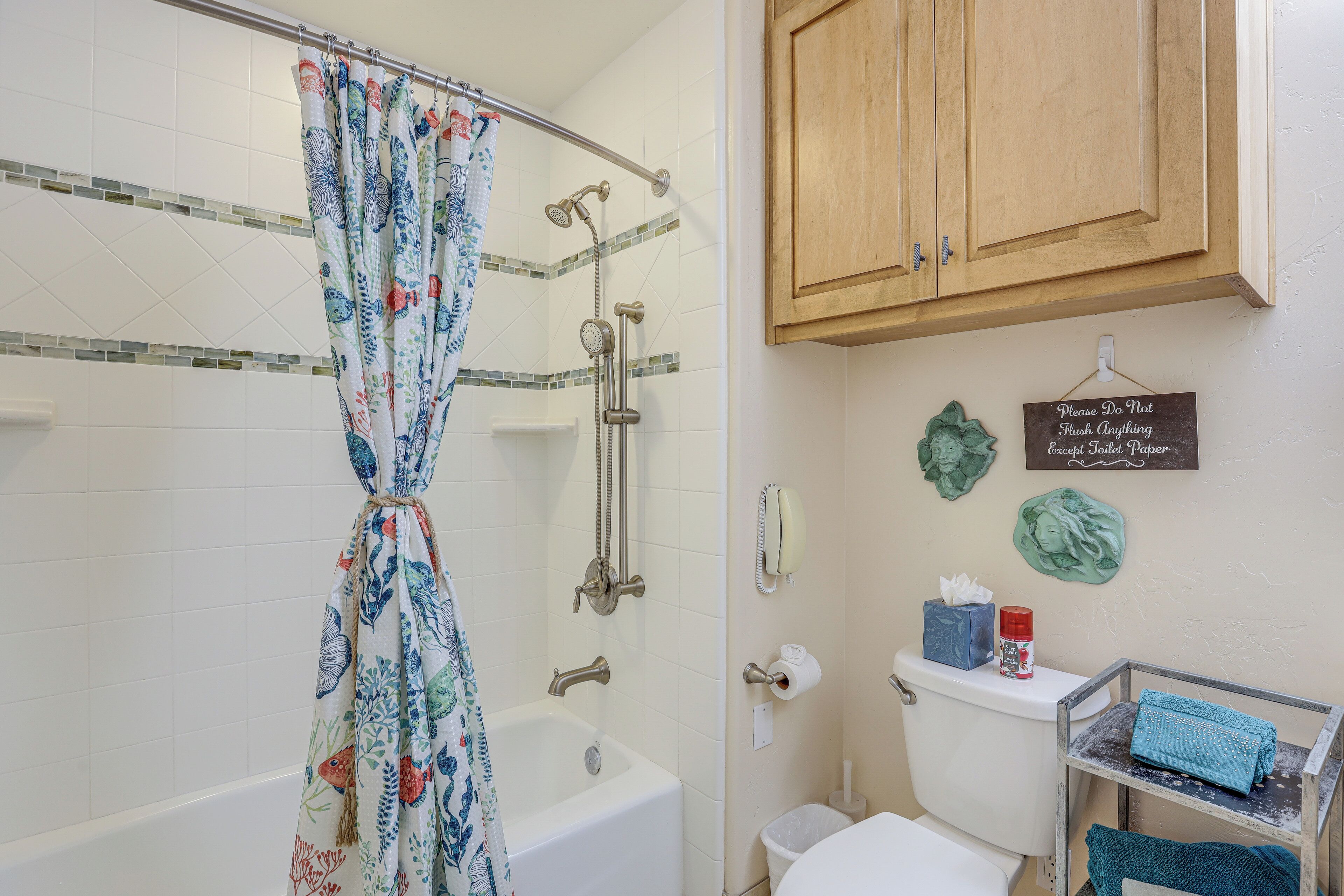 Une salle de bain avec une douche, des toilettes et un meuble.