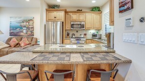 A modern kitchen with granite countertops, stainless steel appliances, and wooden cabinets. - Pismo Beach Vacation Rental - Walk to Town & Ocean (Pismo Beach)