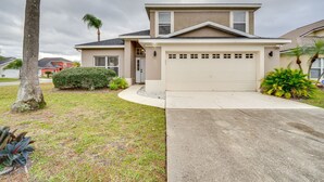 A two-story house with a garage, a driveway, and a well-maintained lawn.