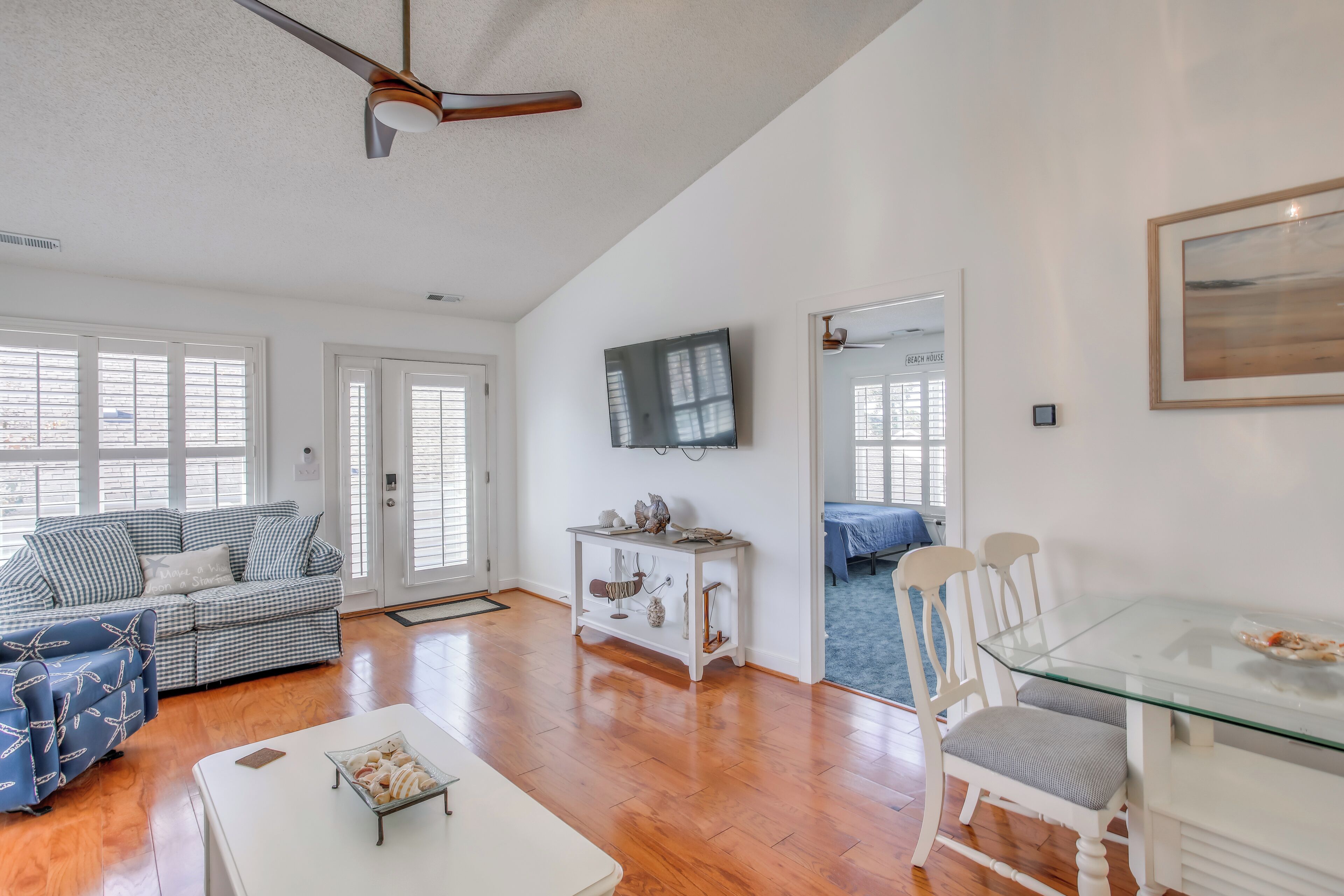 A spacious living room with a sofa, a coffee table, and a glass dining table.