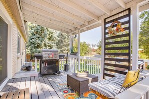 Une terrasse extérieure couverte, équipée d’un barbecue, d’un coin salon et offrant une vue sur le jardin arri ère.