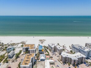 A coastal hotel with multiple buildings, a beach in the background, and clear skies. - 50 Gulf Beach Rd - Unit 1 1 Bedroom Home by RedAwning (Fort Myers Beach)