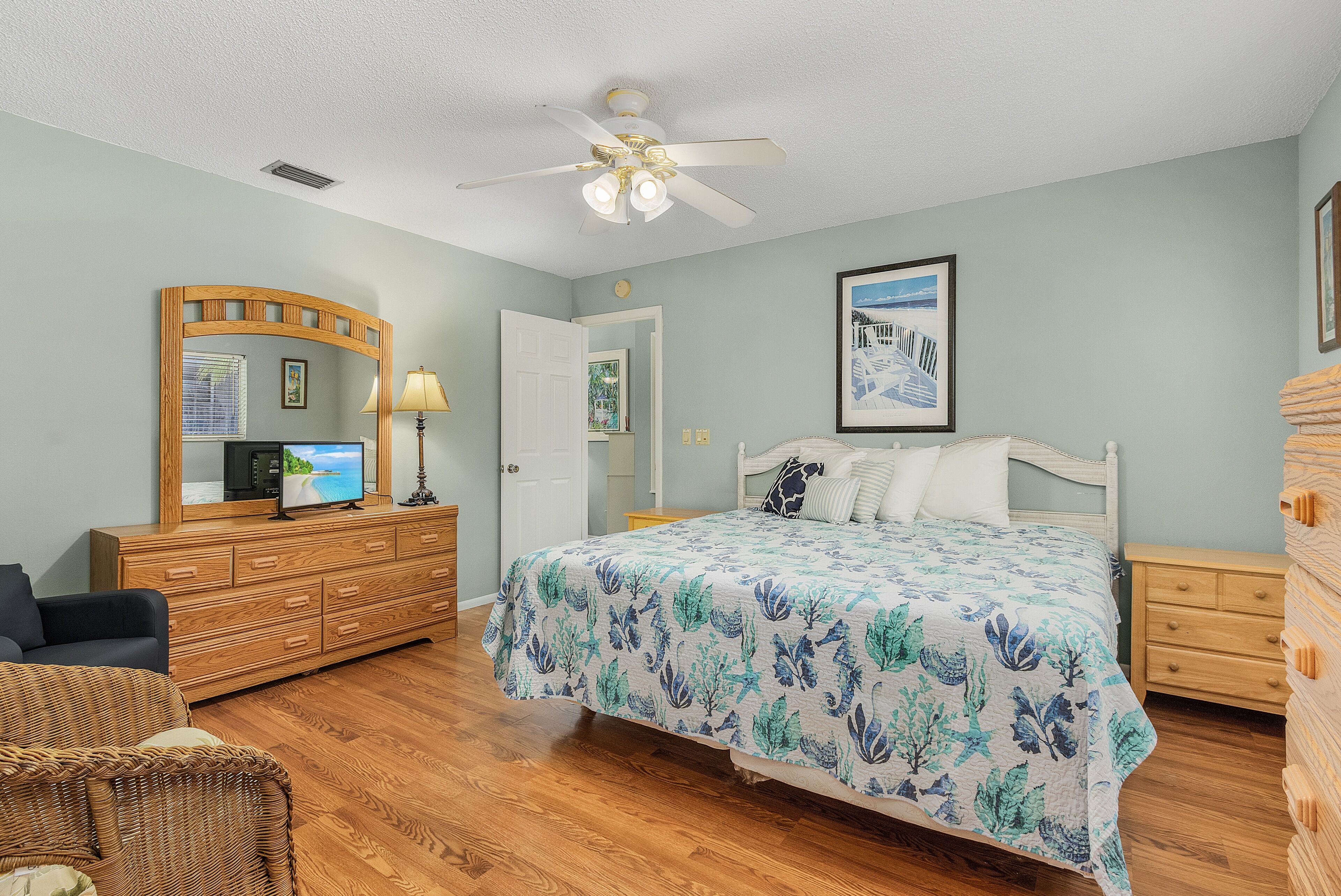 A bedroom with a bed, dresser, and a television on a dresser.