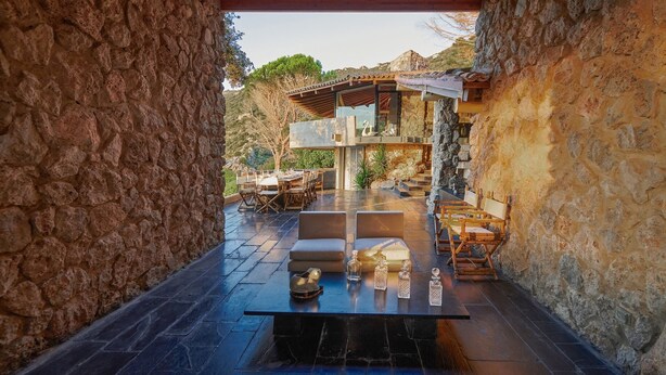 An outdoor dining area with stone walls, a table set for two, and a view of the surrounding landscape. - Cala Piccola, Monte Argentario, Grosseto and Maremma (Monte Argentario)