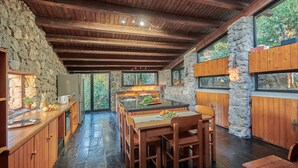 A rustic kitchen with stone walls, wooden beams, and a large island with seating. - Cala Piccola, Monte Argentario, Grosseto and Maremma (Monte Argentario)