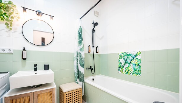 Un baño con lavamanos blanco, mueble de madera y bañera.