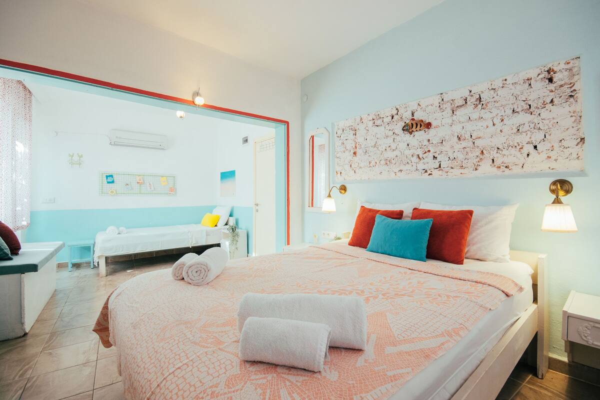 A hotel room with a large bed, a desk, and a bathroom visible through an open door.